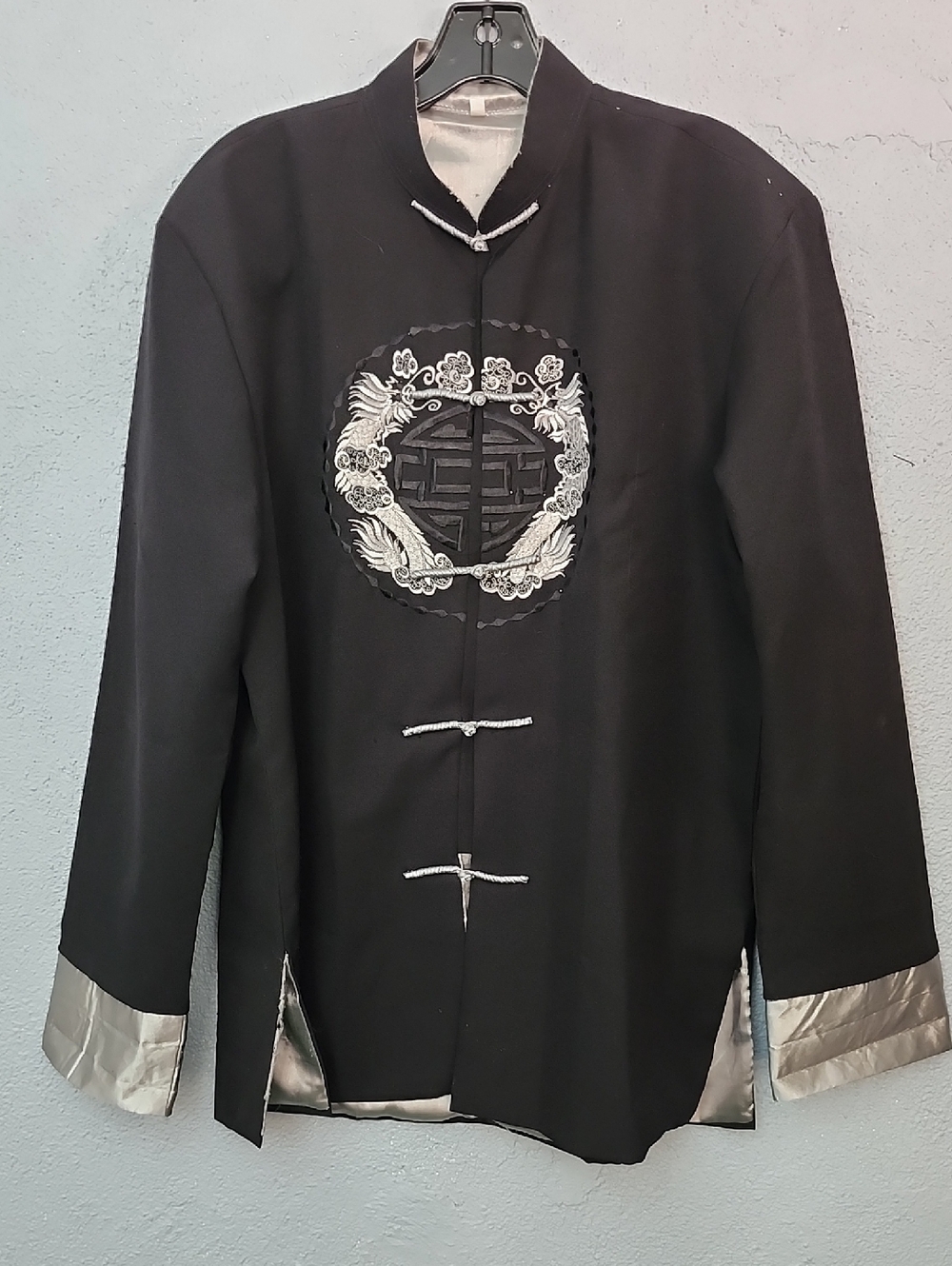Black Chinese Tang suit jacket featuring a mandarin collar and white dragon embr